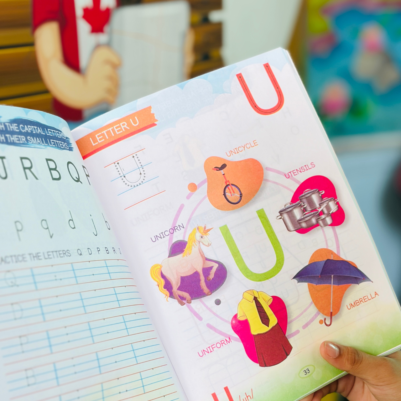 An open page from the Kenbee Smart Book Alphabet Part-D preschool workbook showing interactive activities for the letter U, featuring illustrations of a unicycle, unicorn, uniform, utensils, and umbrella.
